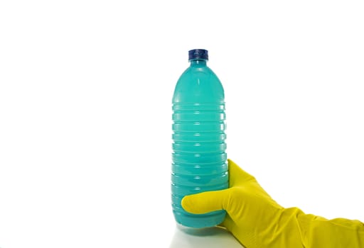 hand with yellow household glove holding a plastic bottle of detergent on a white background