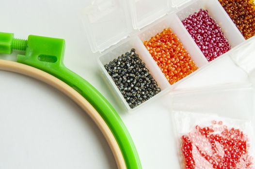 Flat lay Accessories for needlework and embroidery, hoops and beads on white background.