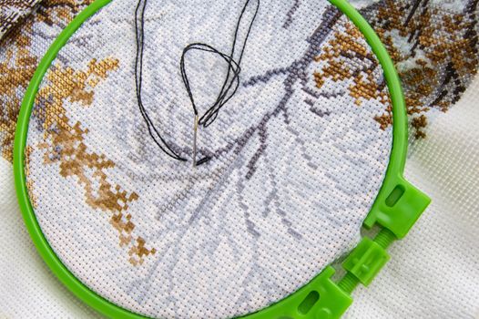 Flat lay embroidery Hoop with canvas and bright sewing thread and embroidery needle.