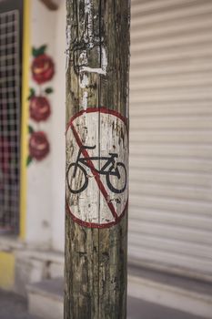 Bicycle ban road sign drawn on a wooden pole