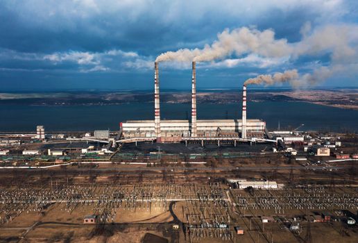 Old thermoelectric plant with big chimneys in a rural landscape. Burshtyn, Ukraine