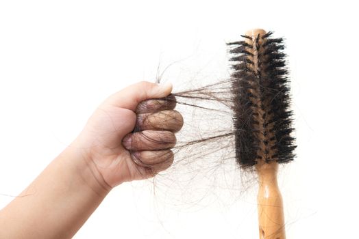 Children hand grabbing lost hair on brush, isolated on white background.