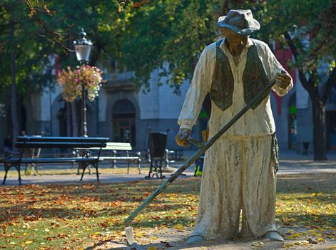 Statue of a traditional scythe man on main square in Subotica, Serbia