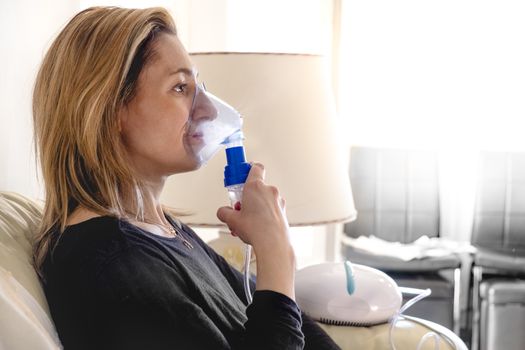 nebulizer aerosol woman inhaler machine medicine at home .