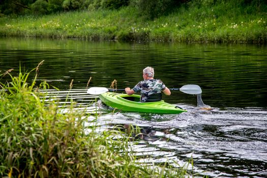 People boating on river Memele in Latvia, peacefull nature scene.