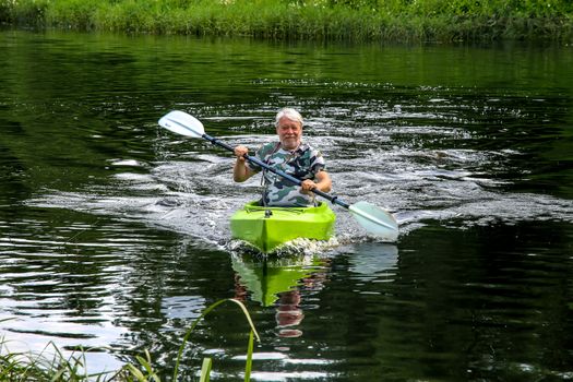 People boating on river Memele in Latvia, peacefull nature scene.
