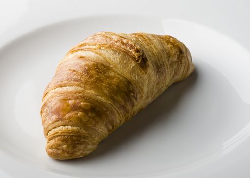 Croissant served on a white porcelain plate.