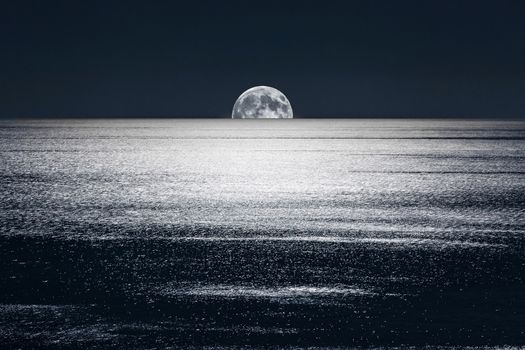 The Full Moon sets into the calm waters of the Mediterranean Sea