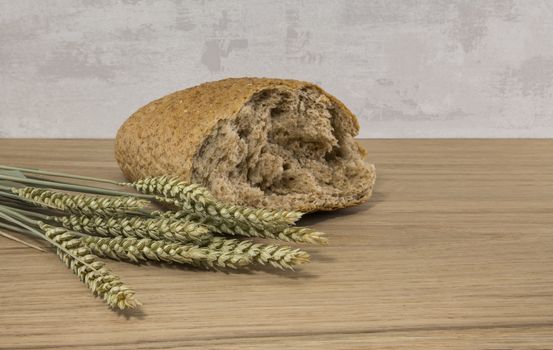 A wheat bread and shock of wheat on a wooden background