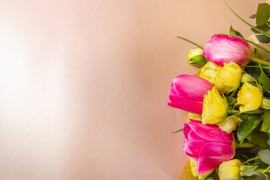 Flat lay flower arrangement with roses and tulips on a pink background top view.