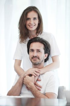 Portrait of happy couple embracing on white background