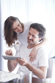 Couple having breakfast at home and using tablet