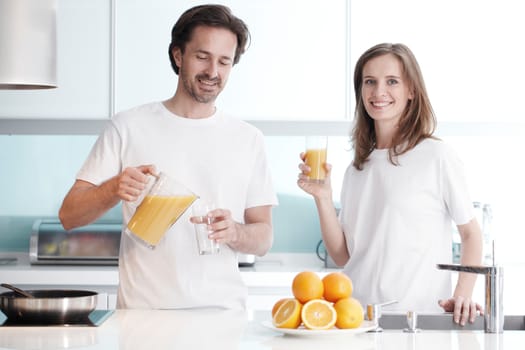 Couple with orange juice in the kitchen