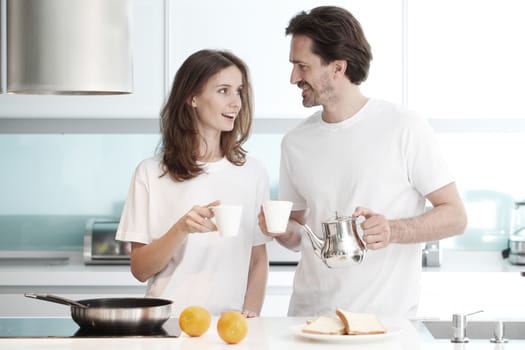 Happy couple cooking breakfast together in the kitchen