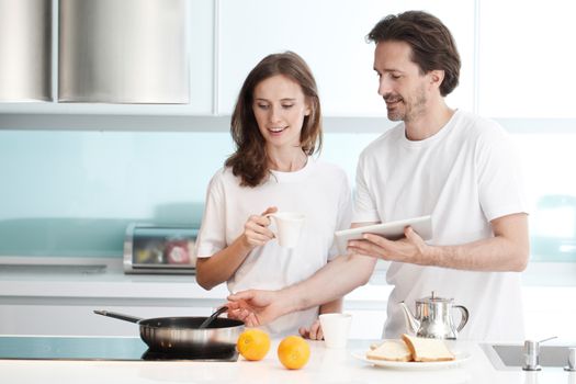 Happy couple cooking breakfast together in the kitchen