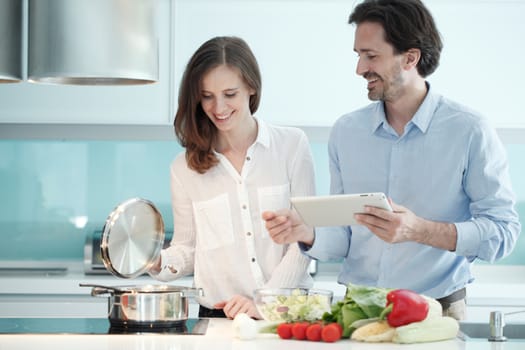 Portrait of a couple having a glass of red wine while cooking dinner