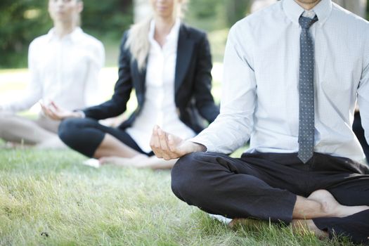 Business people practicing yoga in park