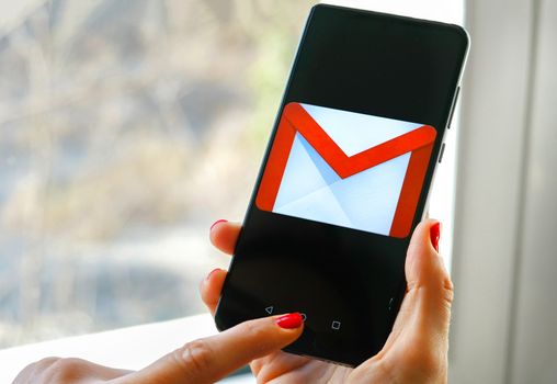 hand check emails with Gmail app by Google on smartphone in Bologna, Italy, 08 March 2019