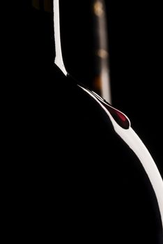 Silhouette of wine bottle, black background, two wine bottles, vertical, wine drop