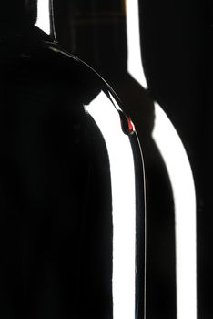 Two bottles of wine, wine drop, black background