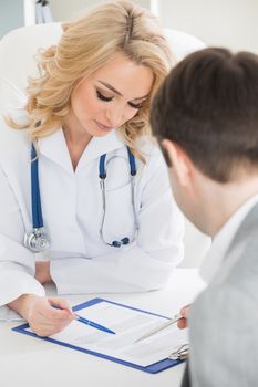 Doctor with patient reading a contract document in clinical office