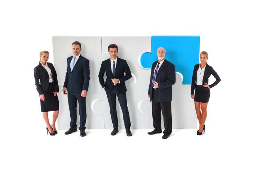 Business teamwork and cooperation concept . Portrait of group of business people with giant puzzle pieces . Partnership and collaborationconcept, studio isolated on white background