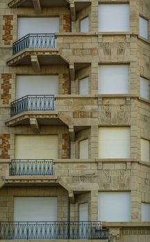 beautiful vintage building with balconies and closed roller shutters, Belgian city architecture