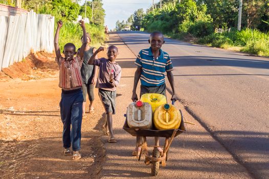 KENYA, THIKA - 28 DECEMBRE 2018 :Four young Kenyans carrying water