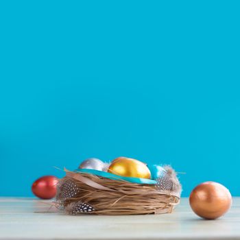 Beautiful Happy Easter holiday greeting banner with easter nest with colored eggs and decorated with ribbons over light wooden background with copy space for text on blue