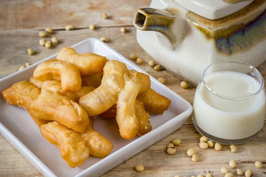 Deep-fried dough stick with Soybean milk and Ceramic hot pot on wood background