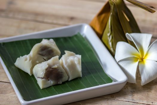 Name is Kanom Sai Sai in Thailand. Put on banana leaf in white disk with Plumeria flower.