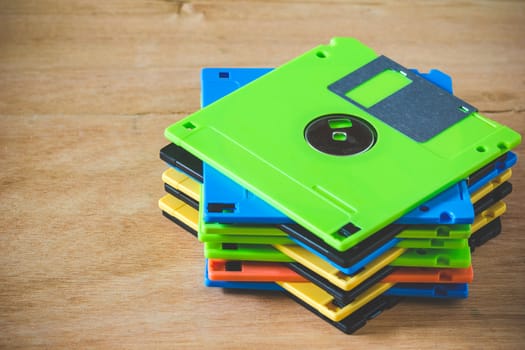 Multicolor diskette stacked on wood background