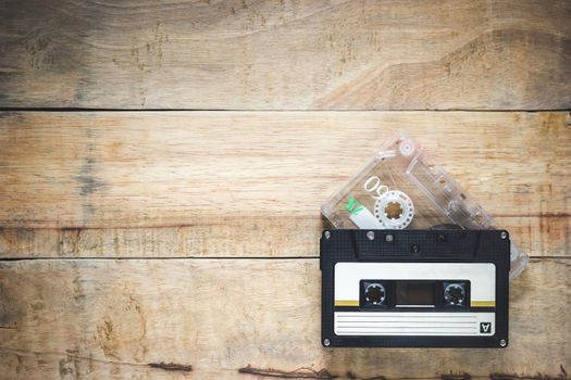 Two cassette in Black and clear color on wood background