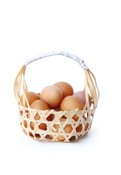 farm fresh chicken eggs in round bamboo basket isolated over white background, clipping path. 