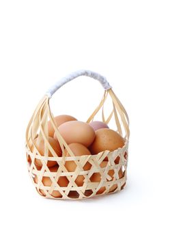 farm fresh chicken eggs in round bamboo basket isolated over white background, clipping path. 