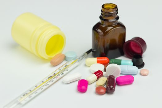 Colorful antibiotic, Medicine pills or capsules and thermometer on white background.