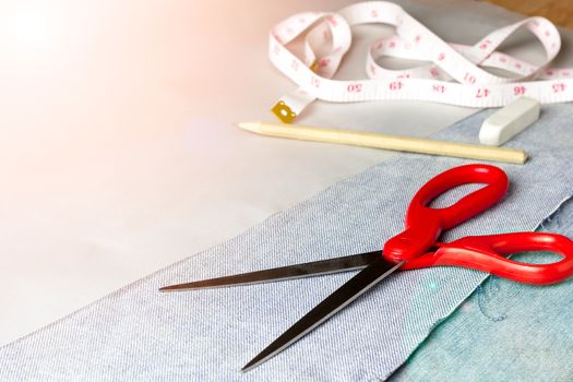 Equipment for jeans fabric cutting on brown wood background.