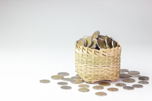 Many coin in a bamboo basket on white background. Concept financial or business. Keep saving money for good thing in the future.