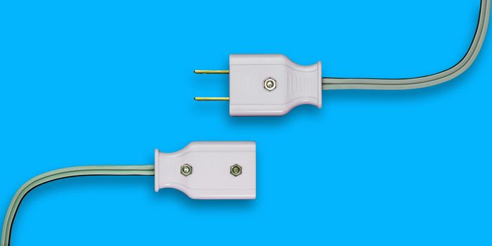 AC power plug with electrical cable on blue background.