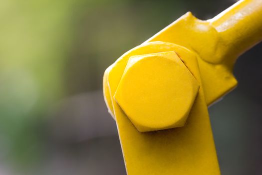 Yellow stainless steel fasteners.The bolt attaches the two steel pieces together to form the mechanism of the machine.