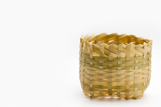 The small basket is made from bamboo, laid on white background.