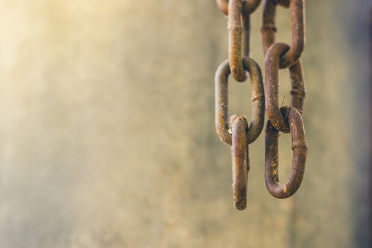 Two old rusty chains were hanging down from above, Beside the wall, Copy space on cement background.