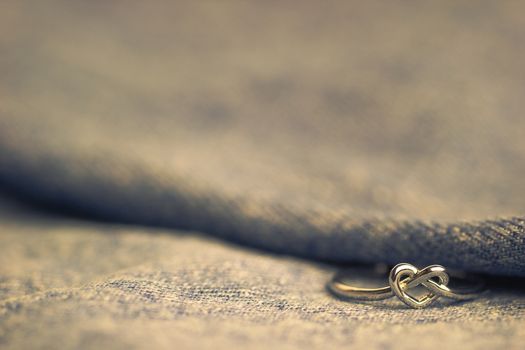 Heart shaped ring laying on Jeans jecket. The concept of love or marriage. Copy space can be used to write articles about Valentine's Day.
