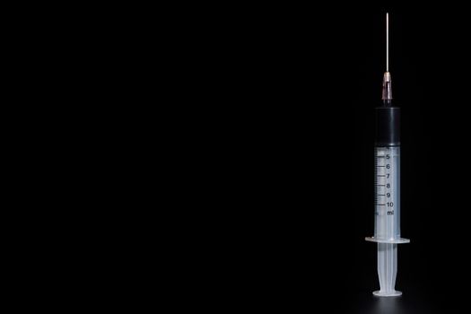 Fake blood in syringe on darkness background. Concept of health and substance abuse.
