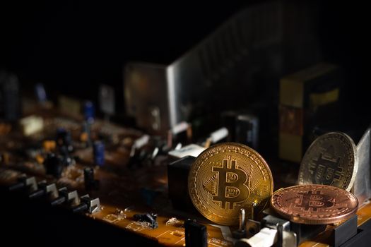 Bitcoin placed on the circuit of electronic mainboard. Concept of bitcoin mining business.