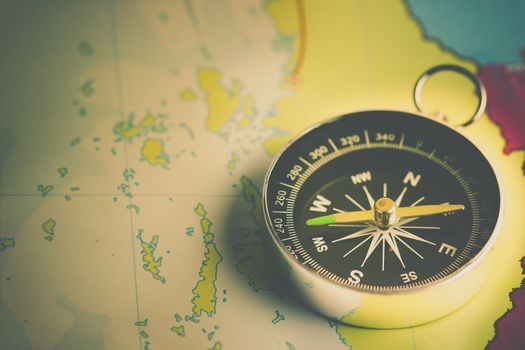 Compass laid on a paper map. The concept of travel.