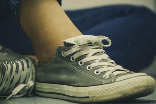 Women sit on the floor and lace up sneakers. The concept of travel or adventure.