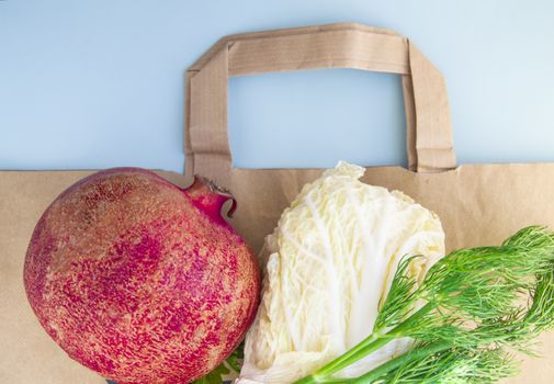 Flat lay, Healthy fruits and vegetables for proper nutrition on top of a paper bag, the concept of abandoning plastic bags and shopping at a diet for weight loss. The view from the top.