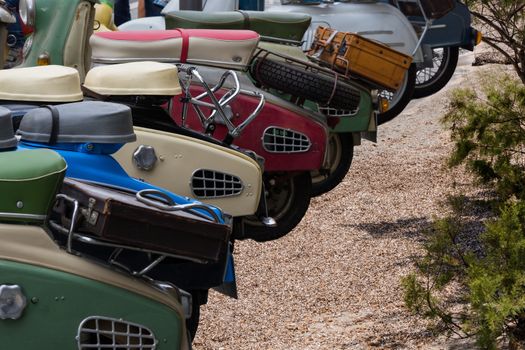 Various retro scooters line the road in a row.