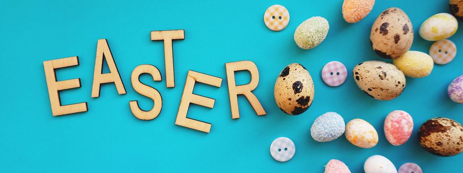 Quail Easter eggs on blue background. Flat lay, top view. Easter concept banner. Easter text